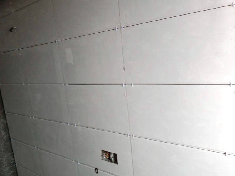 衛(wèi)生間貼瓷磚裝修：廚房貼瓷磚，客廳吊頂：首先應除去基層表面的污垢，油漬，浮灰;除去基層上所有涂料層，膩子層;如果基層未能達到平整度要求，需對基層進行預先的找平處理；接著加水后將粘結劑漿料攪拌至潤滑均勻，無明顯塊狀或糊狀結塊，攪拌后的漿料靜置5-10分鐘后再稍加攪拌1-2分鐘即可使用；然后將瓷磚平整地鋪貼在基層上，使用橡膠錘將瓷磚拍實鋪平。施工過程中，可小幅度轉動瓷磚，使?jié){料與瓷磚背面充分接觸。根據磚的尺寸，在磚與磚之間預留相應尺寸的縫隙留待嵌縫，瓷磚鋪貼結束后24小時，可進行嵌縫施工。最后將調制好的嵌縫劑均勻地涂在磚與磚的地方。