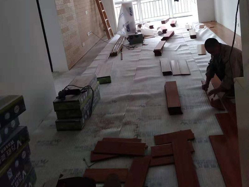 客廳地板鋪貼：先大家應對是施工地進行清理，把無關的東西都移出去，并且把地面上的垃圾清掃干凈，包括每一個角落。然后對地面進行找平，水平誤差不能超過2mm，超過的話就要想辦法找平了。地面要是不平，地板鋪好后腳感當然也就不好了。再就是將邊、角部位等地面突起或不平的局部修整過來。木地板遇潮后易起拱、變形,為了避免這種情況,大家需要對地面進行防潮處理。常見的處理方法是在地面上鋪防潮層，這樣可以防止以后地板受潮。防潮層要鋪平，接縫處要并攏。
